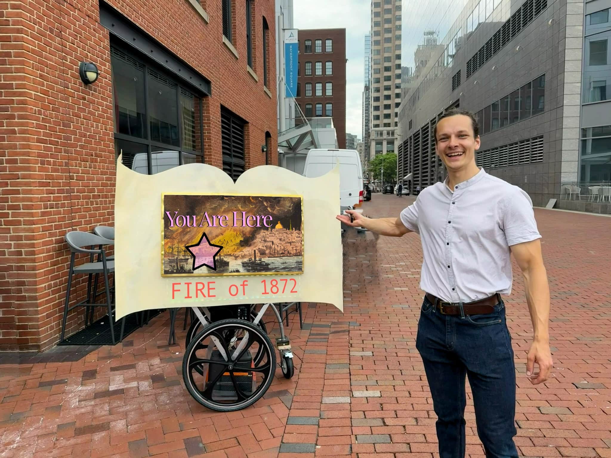 Beaming Boston Tours guide pointing at the 'You Are Here — Fire of 1872' cart sign on a Boston plaza